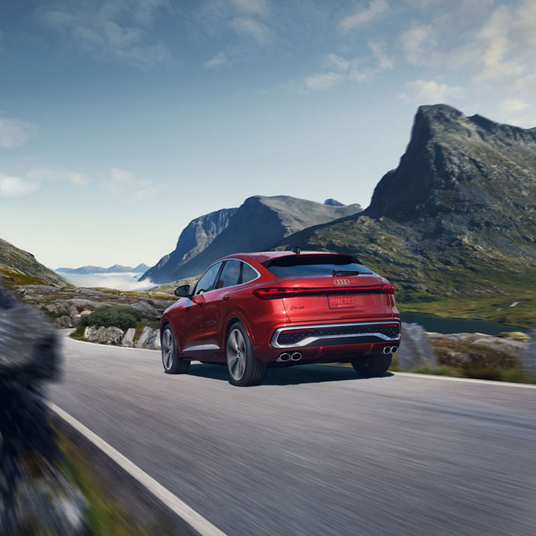 Three-quarter rear view of the all-new Audi SQ5 Sportback in motion on a mountain road.