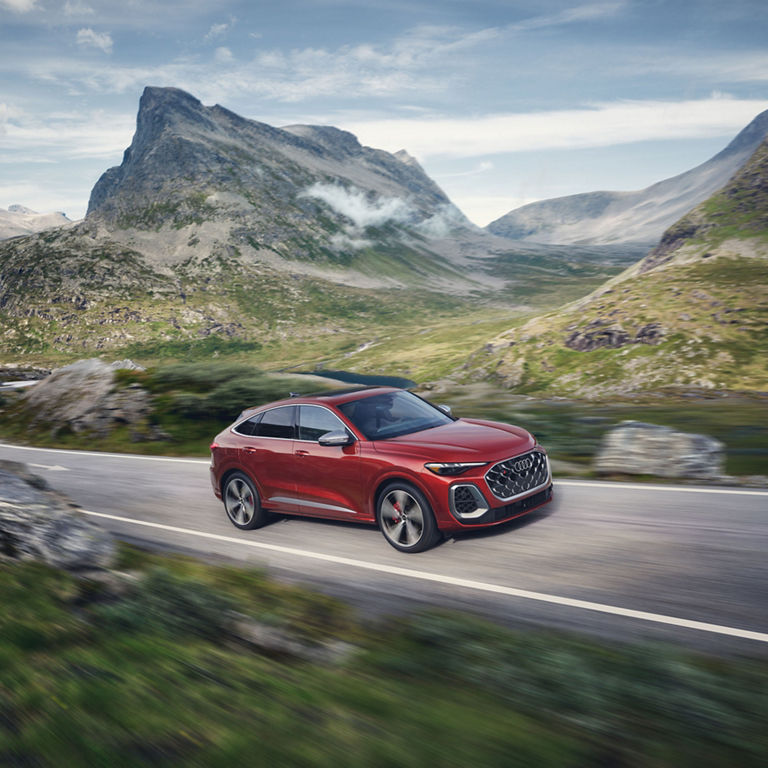 Three-quarter side view of the all-new Audi SQ5 Sportback accelerating on a mountain road.