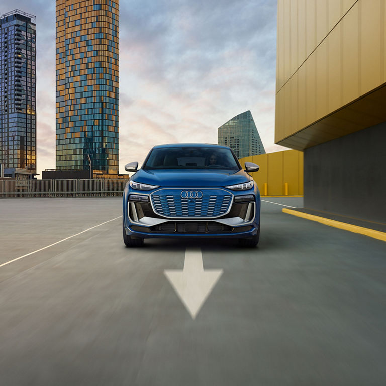 Front profile of a blue Audi SQ6 Sportback e-tron in motion.