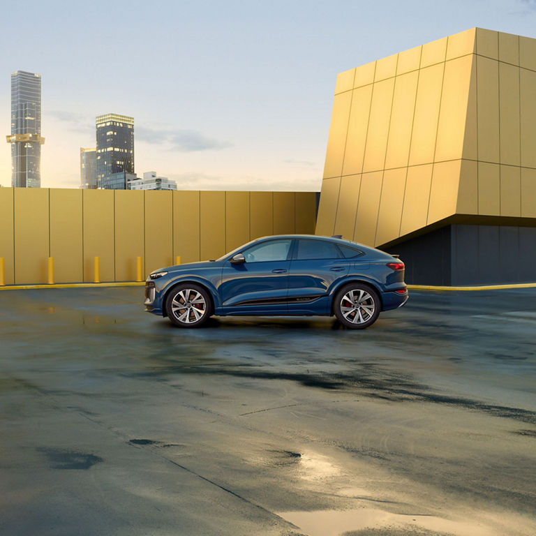 Side profile of a blue Audi SQ6 Sportback e-tron parked.