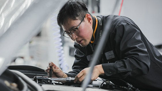 An Audi technician working on a vehicle. 