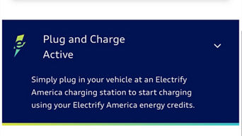 A red Audi RS e-tron GT plugged into a charging station at sunset.