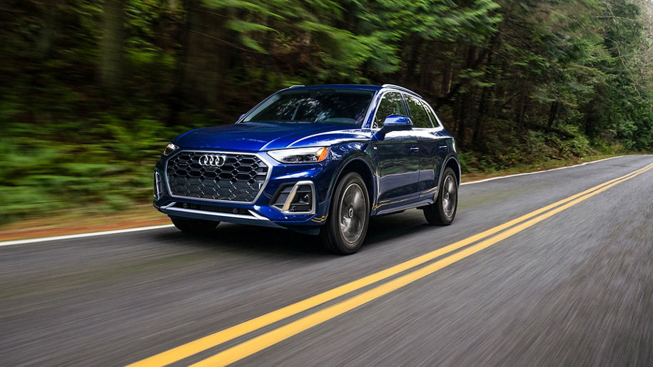 Three-quarter front view of a blue Audi Q5 driving down the road. 