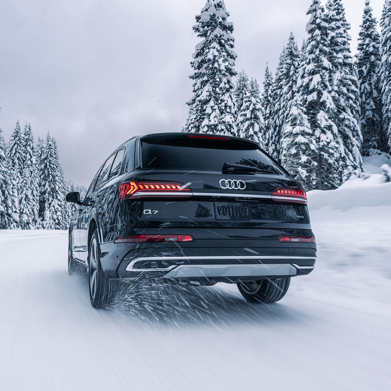 Three-quarter front profile of an Audi Q8 e-tron accelerating on a hill road.