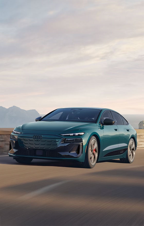 Three-quarter front profile of an Audi Q8 Sportback e-tron parked and charging on a driveway. 