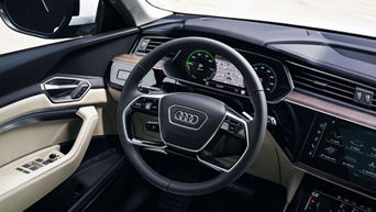 Close-up on the steering wheel, dashboard, and cockpit in an Audi vehicle.