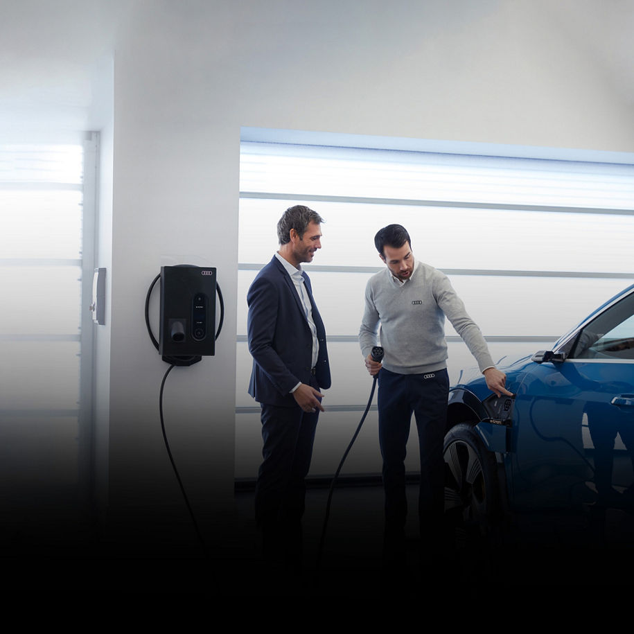 An Audi dealer showing a customer how to charge his Audi e-tron vehicle.