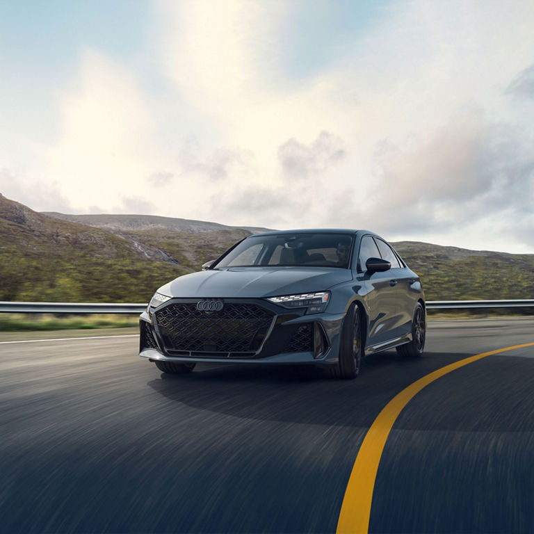 Three-quarter front view of the Audi RS 3 accelerating.