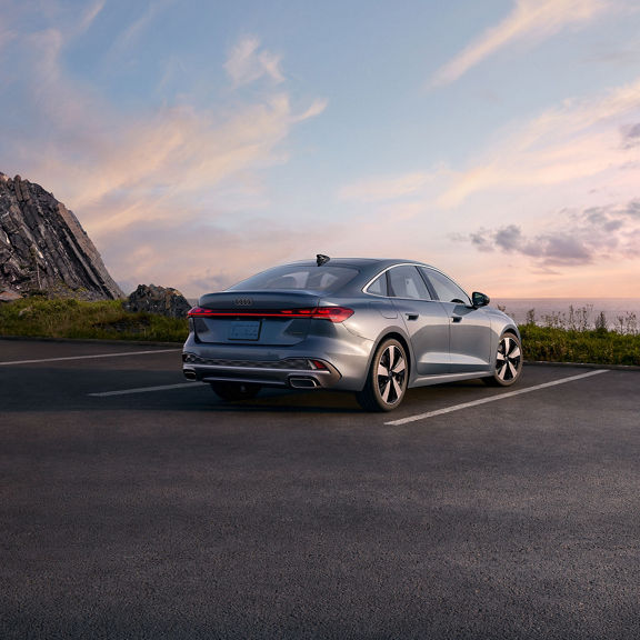 Three-quarter rear view of the all-new Audi A5 parked on an overlook.