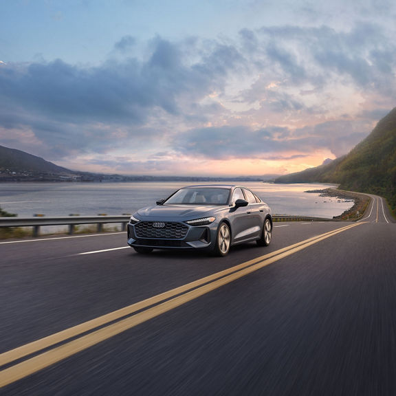 Front view of the Audi A5 accelerating on an oceanside road.