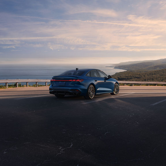 Three-quarter rear view of the Audi S5 accelerating on an oceanside road.