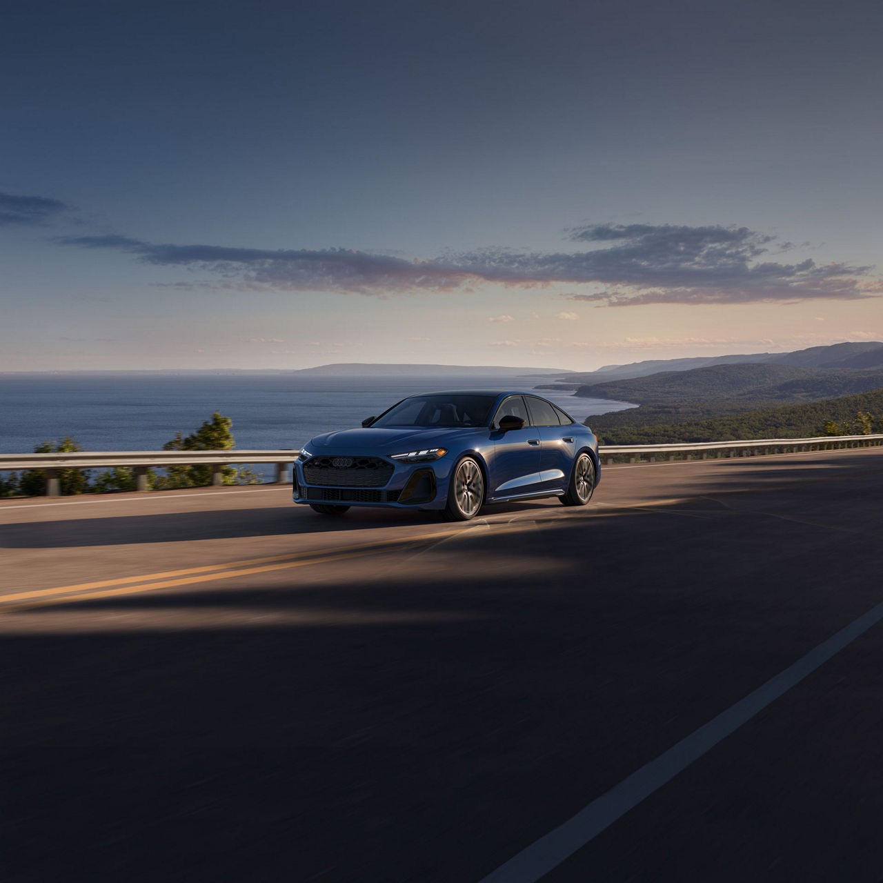 Three-quarter front view of the Audi S5 accelerating on an oceanside road.