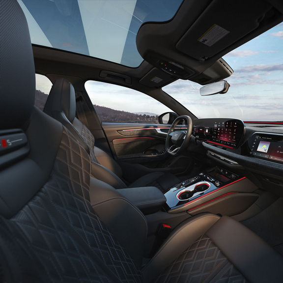 Interior of the Audi A6 Sedan, showing the front sport seats, dashboard, and center console.