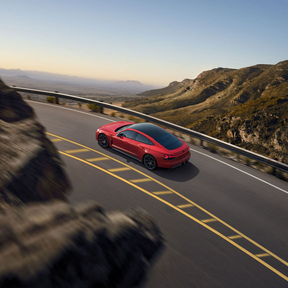 Rear aerial view of the Audi RS e-tron GT in motion.