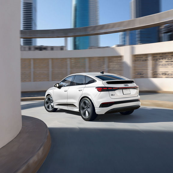 Rear profile of the Audi Q4 Sportback e-tron making a turn. 