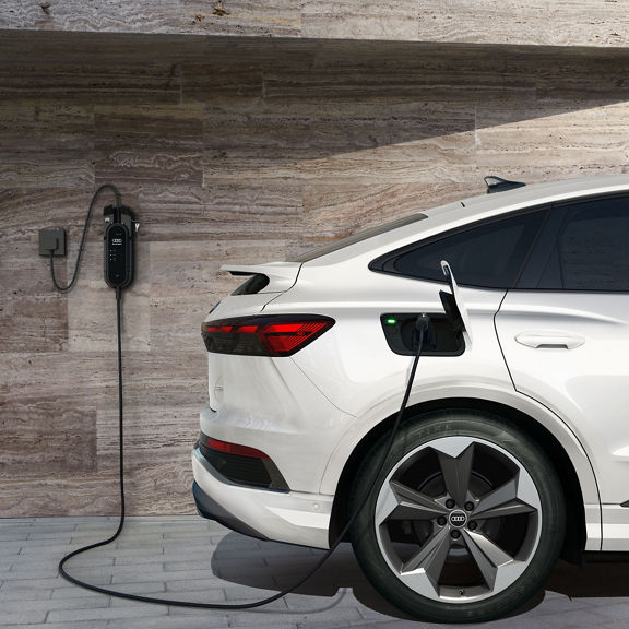 Side view of the Audi Q4 Sportback e-tron® parked and charging.