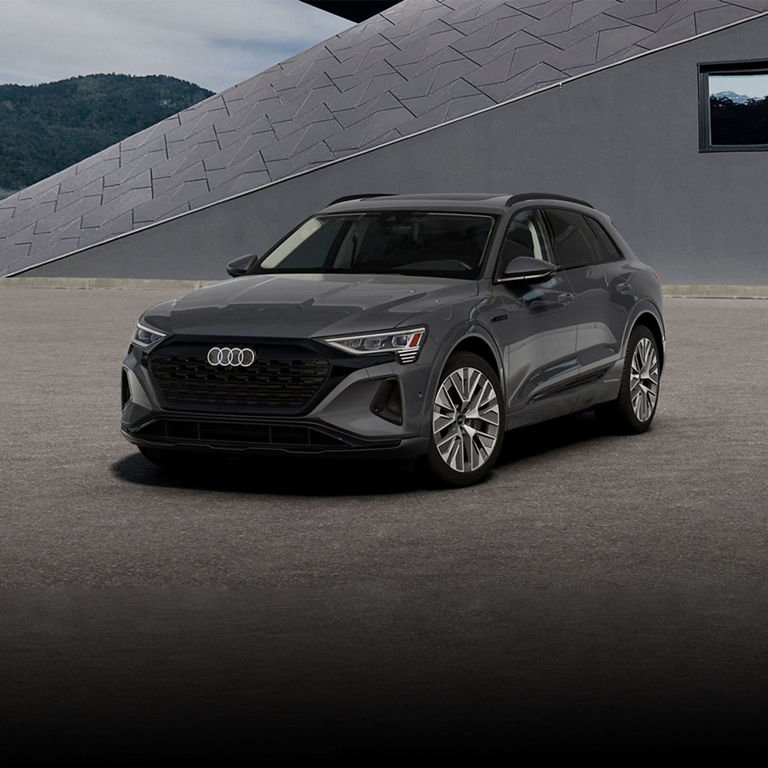 Elevated three-quarter front profile of a gray Audi Q8 e-tron®.