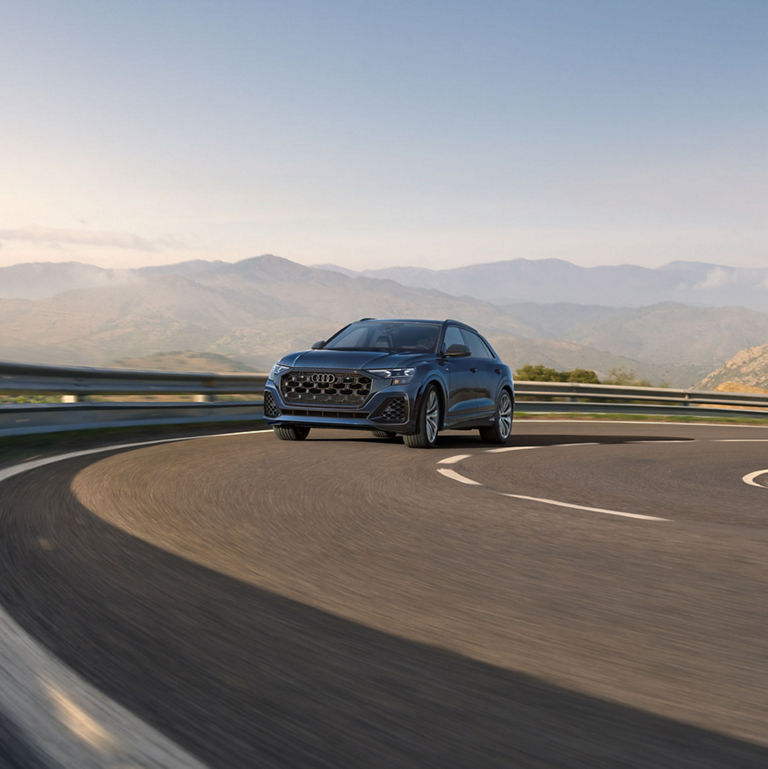 Three quarter front view of the Audi Q8 accelerating.