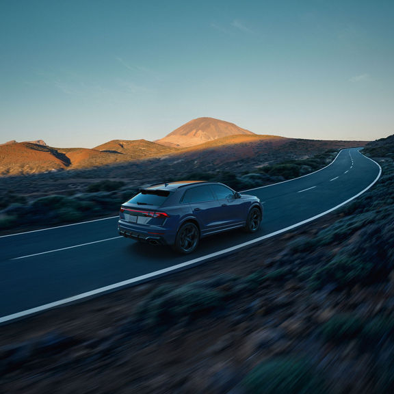Aerial rear view of the Audi RS Q8 accelerating on a hilly road.