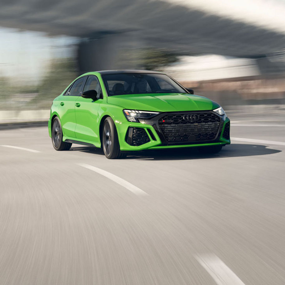 Three-quarter front view of the Audi RS 3 accelerating.