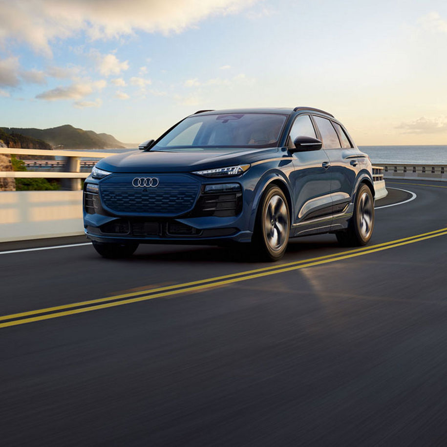 Three-quarter front profile of the Audi Q6 e-tron in motion.