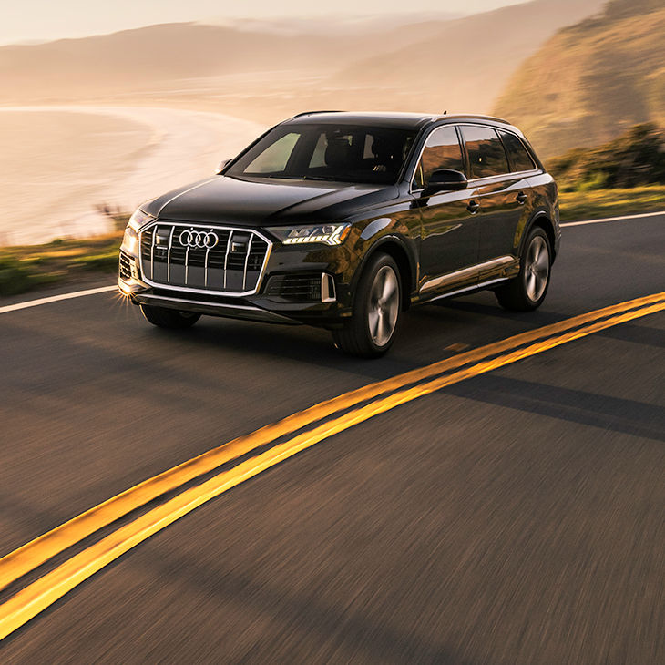 Three-quarter front profile of the Audi Q7 accelerating.