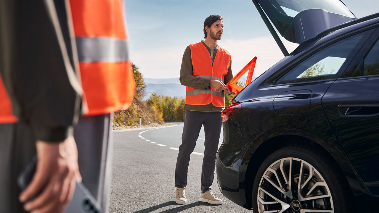A close-up photo of an Audi Certified Technician in a collision repair shop fixing the wheel of an Audi vehicle.
