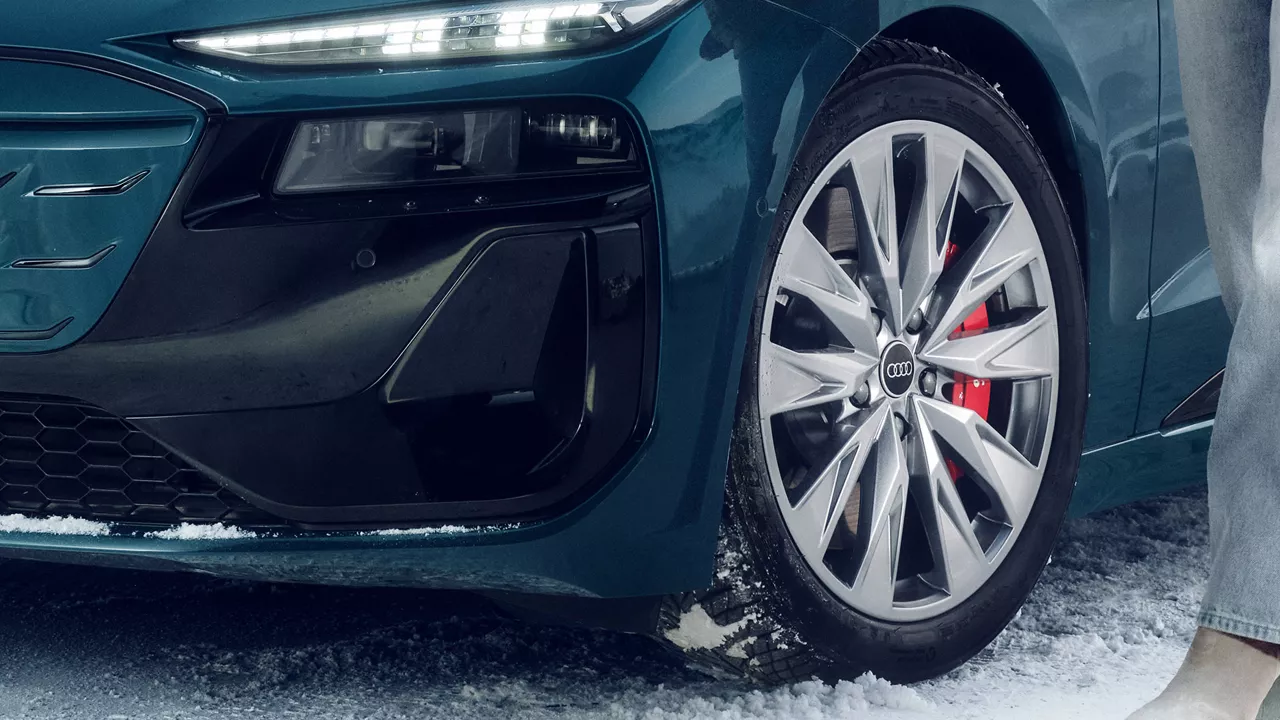 Close-up of the Audi Original Winter Tires that are designed to remain pliable below 45°F with person in the background taking a picture. 