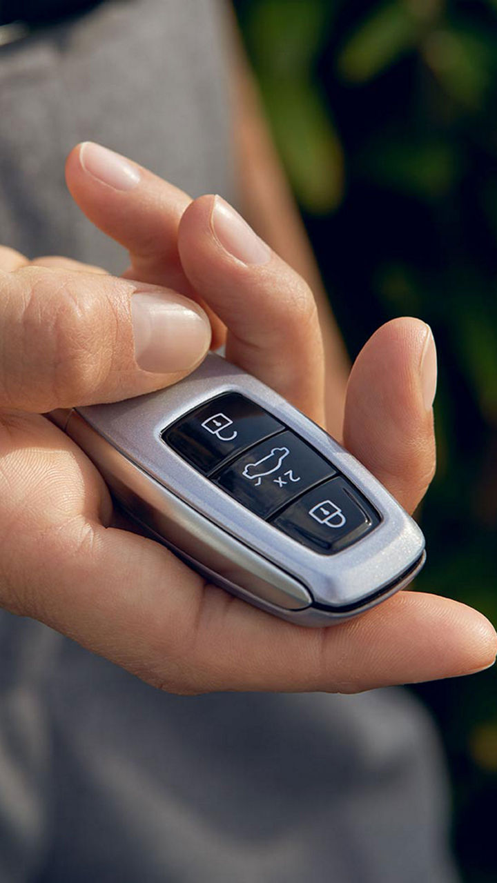 A close-up photo of someone's hand holding an Audi key fob.