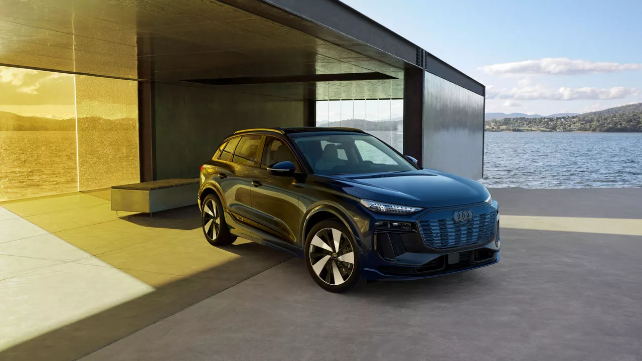 Three quarter profile view of an Audi Q6 parked.