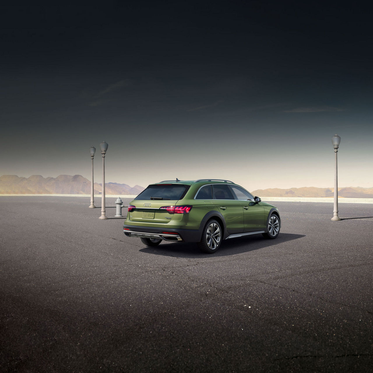 Three-quarter rear view of a green Audi A4 allroad in a mountain parking lot. 