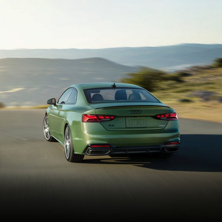 Three-quarter rear view of the Audi A5 Coupé accelerating.