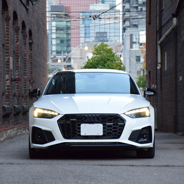 Front profile of the Audi A5 Sportback, showing the lit up headlights.