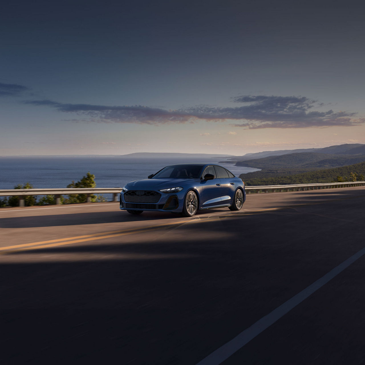 Three-quarter front view of the Audi S5 accelerating on an oceanside road.