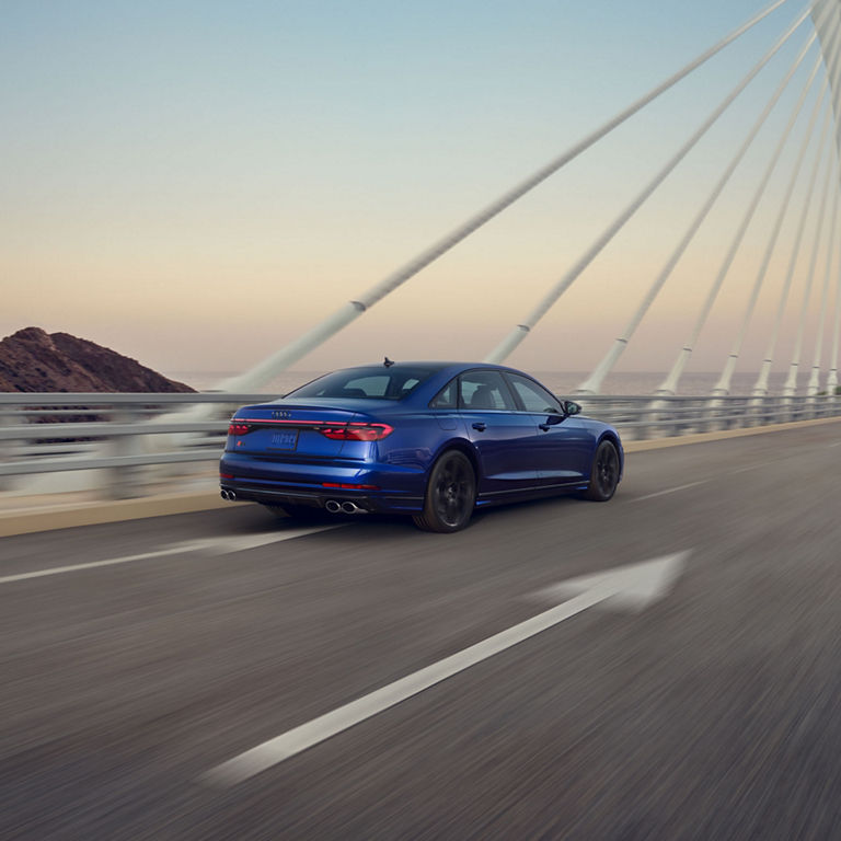 Three-quarter rear view of the Audi S8 accelerating.