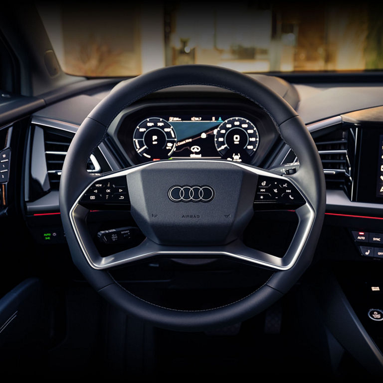 Close-up of steering wheel and console of the Audi Q4 e-tron. 