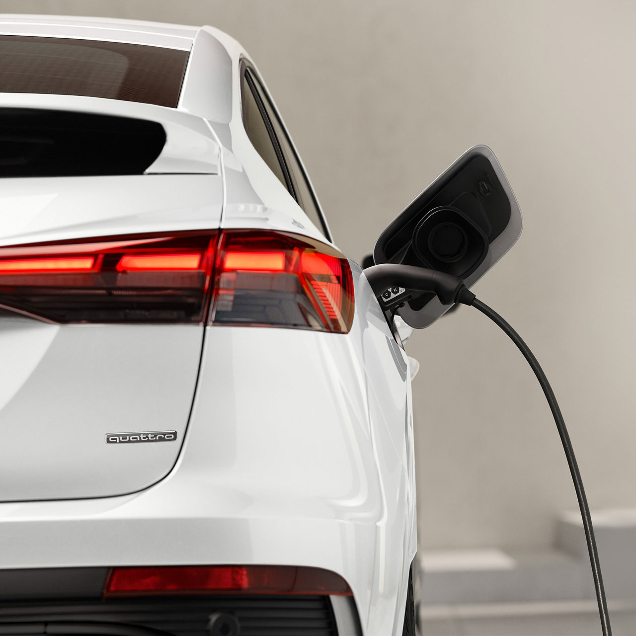 Gros plan d’un Audi Q4 e-tron blanc en recharge. 