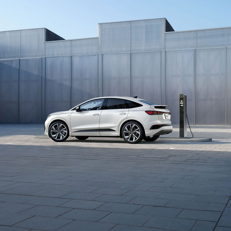 Side profile of an Audi Q4 Sportback e-tron parked and charging.