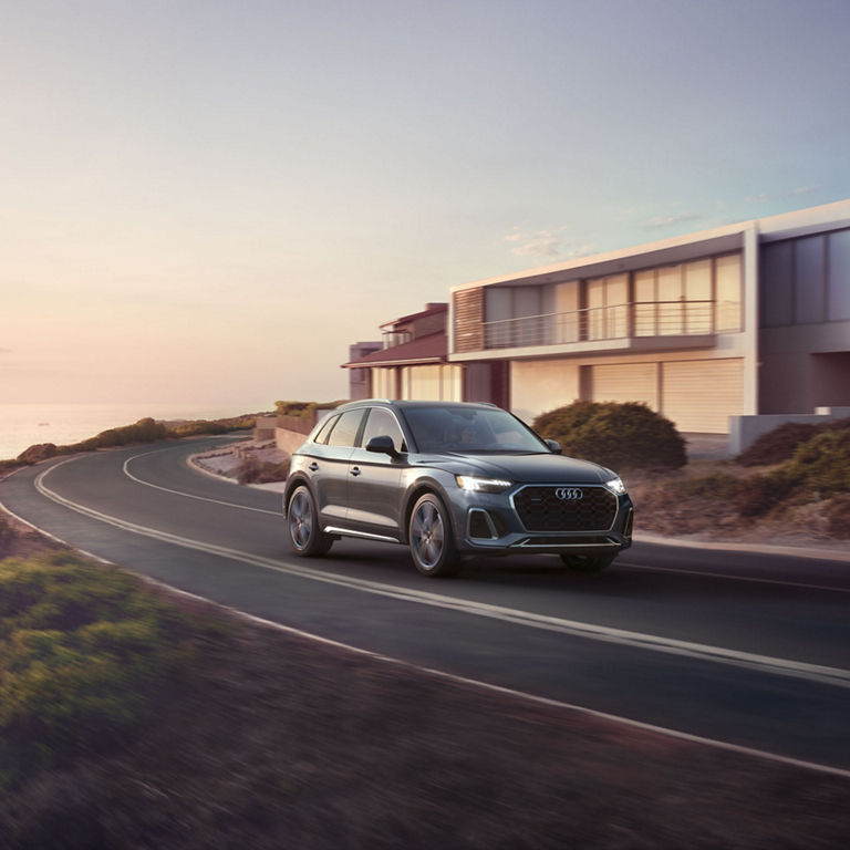 Three-quarter front view of the Audi Q5 TFSI e accelerating.
