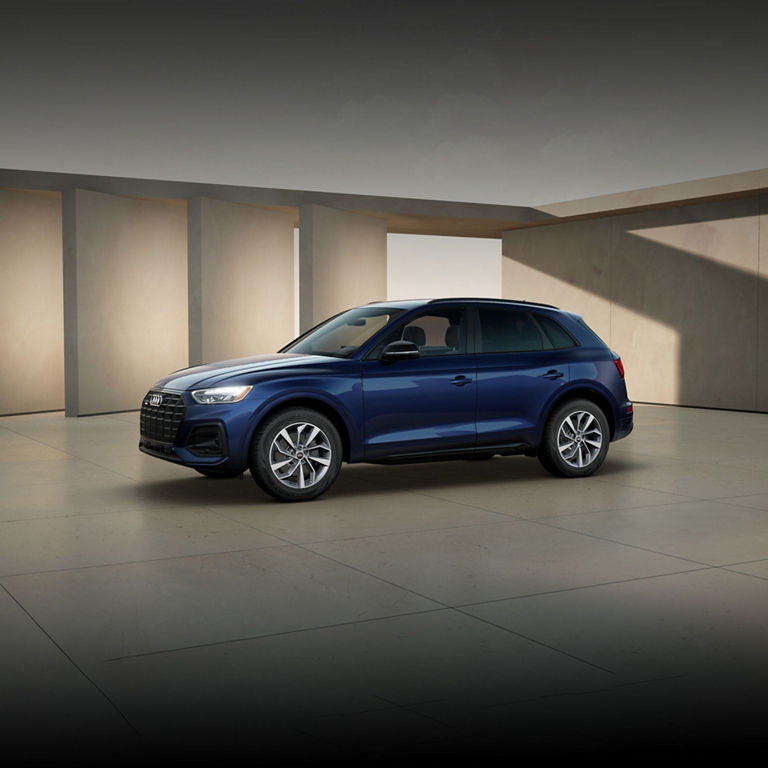 Three-quarter side view of the Audi Q5 parked by a modern building.
