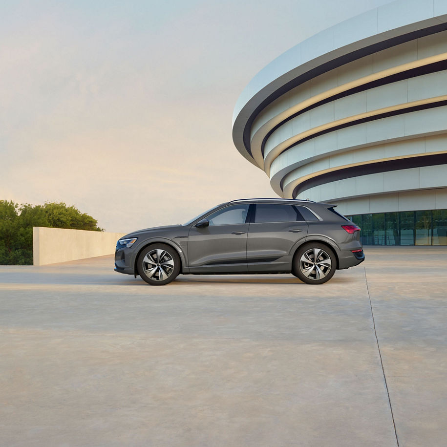 Profil latéral d’un Audi Q8 e-tron gris stationné.