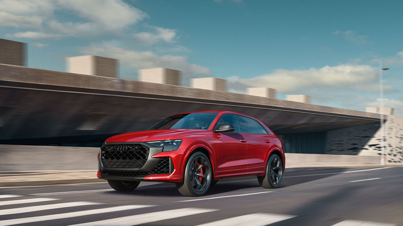 Three-quarter front view of a red Audi RS Q8 in motion.