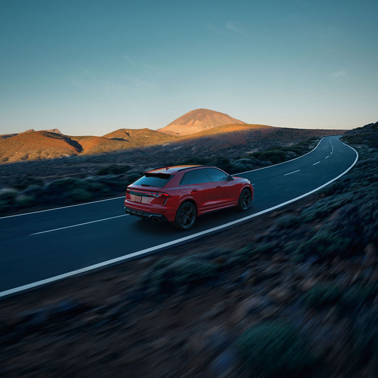 Aerial rear view of the Audi RS Q8 accelerating on a hilly road.