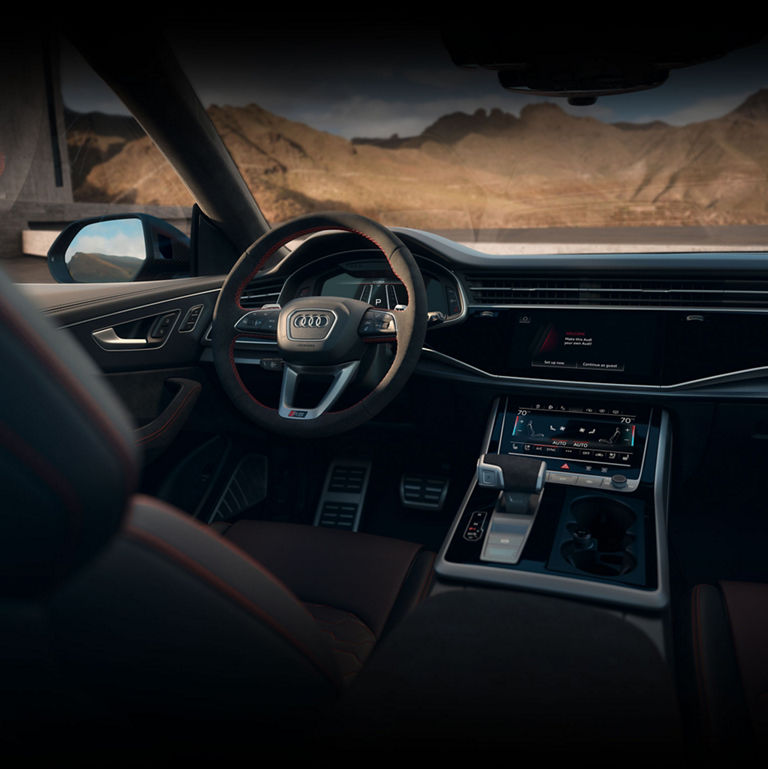 View of the interior cabin showing the steering wheel, dashboard, and center console of the Audi RS Q8.