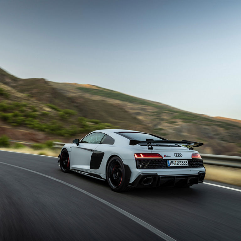 Three-quarter rear view of an Audi R8 accelerating. 