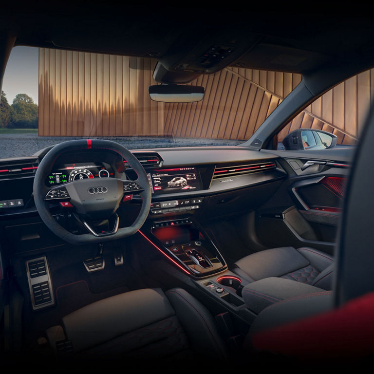 Vue de l'habitacle intérieur de l'Audi RS 3, montrant le cockpit virtuel, les volants et les palettes de changement de vitesse en acier.