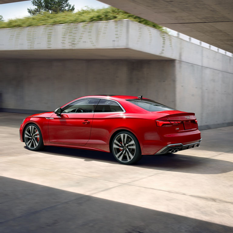 Elevated three-quarter rear view of the Audi S5 Coupe accelerating.