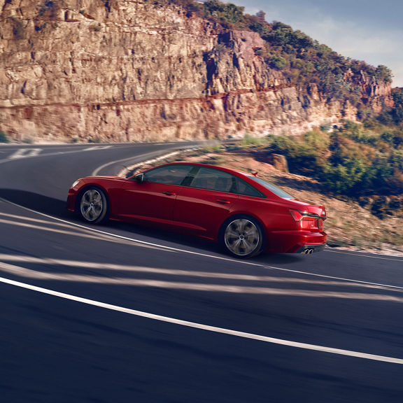 Three quarter side view of the Audi S6 Sedan accelerating.