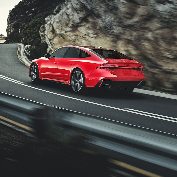 Three-quarter rear view of the Audi RS 7 accelerating.