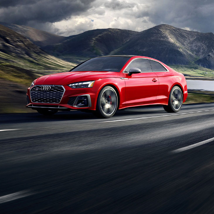 Three-quarter front view of the Audi S5 Coupé accelerating.